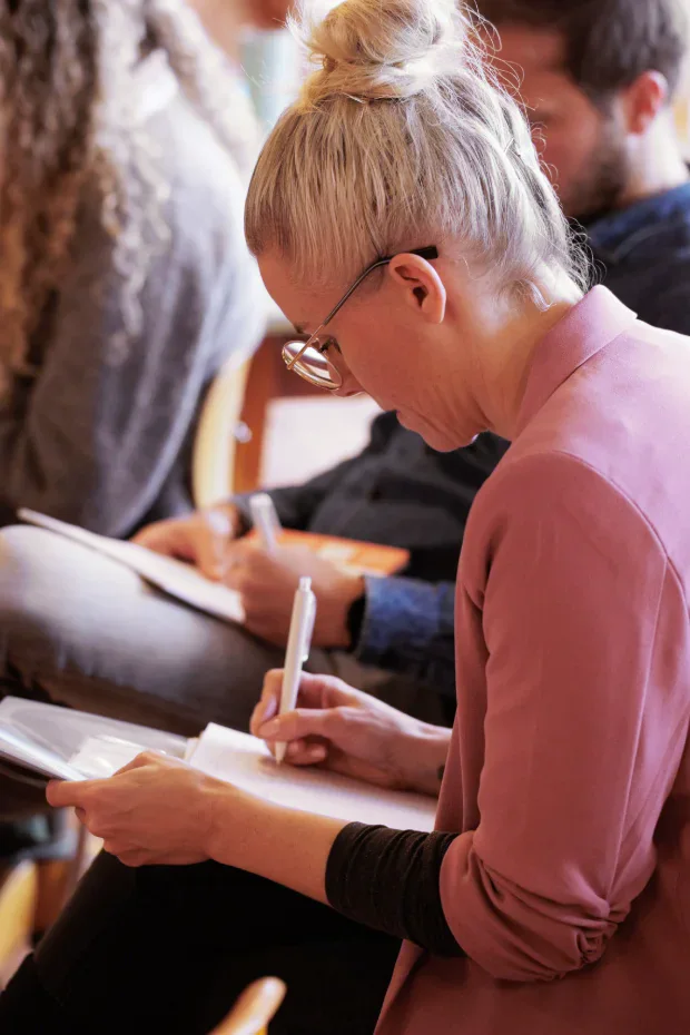 Teilnehmerin macht Notizen im Workshop